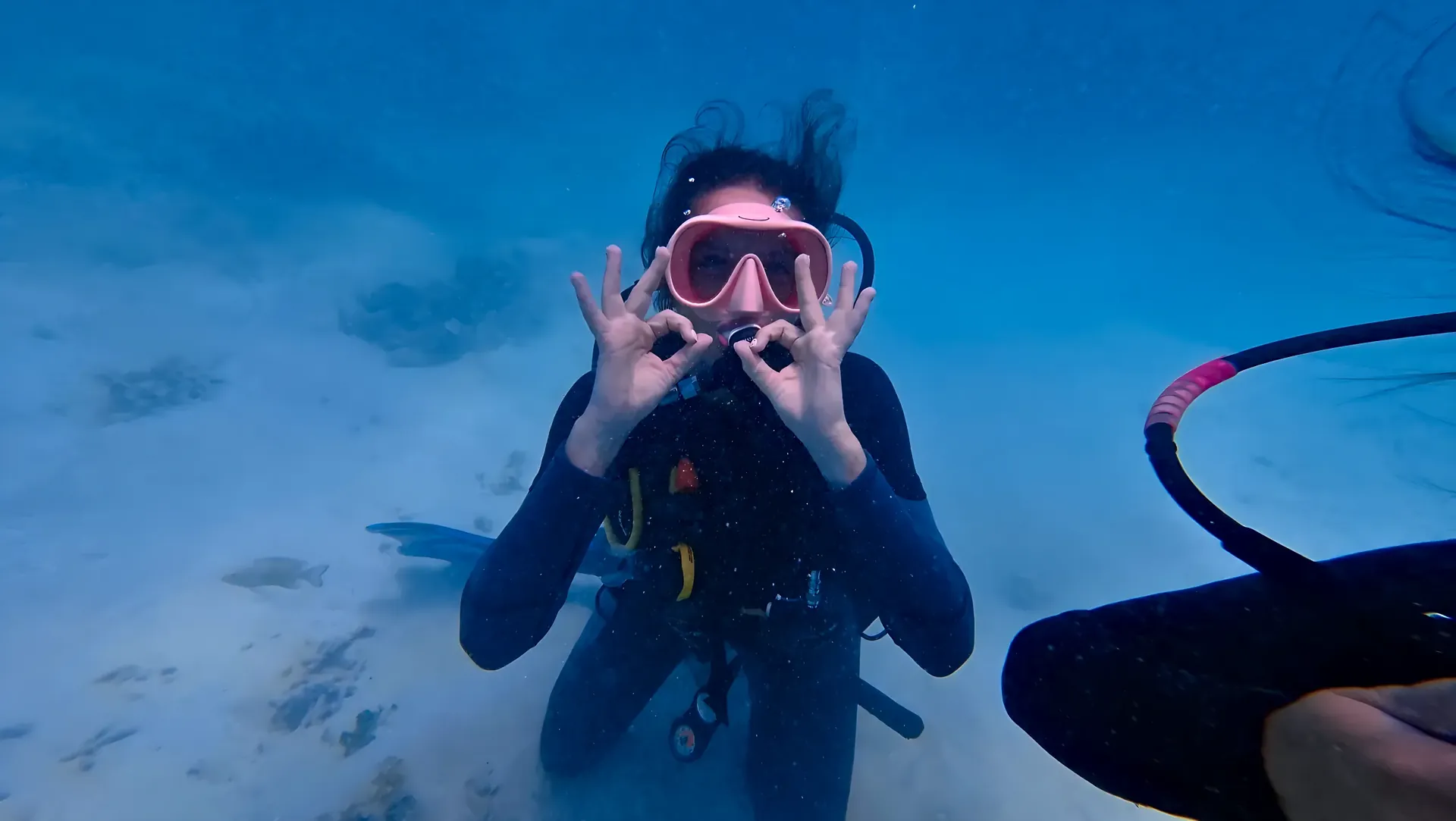 First-time diver making the OK sign underwater
