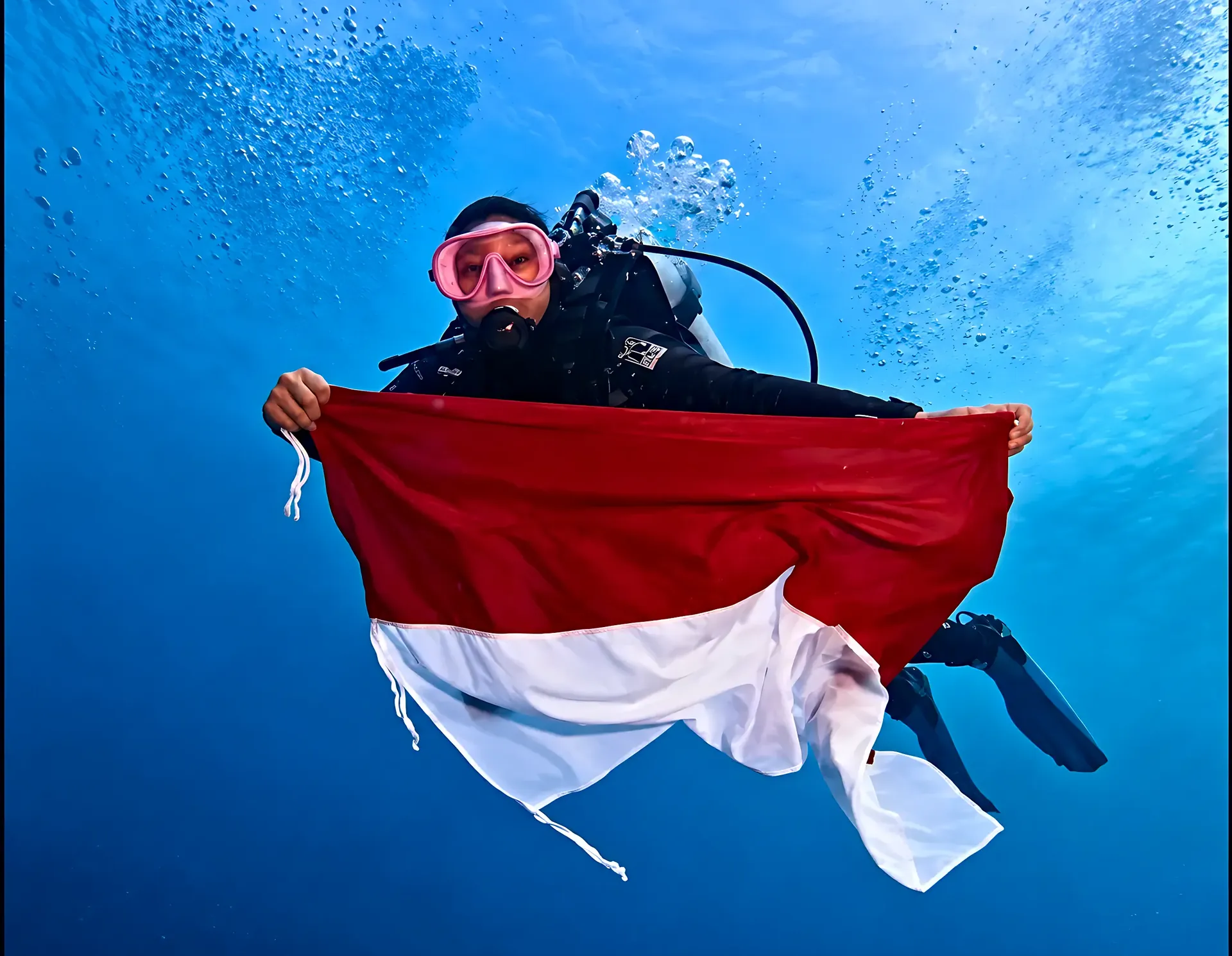 Diver holding the Indonesian flag underwater