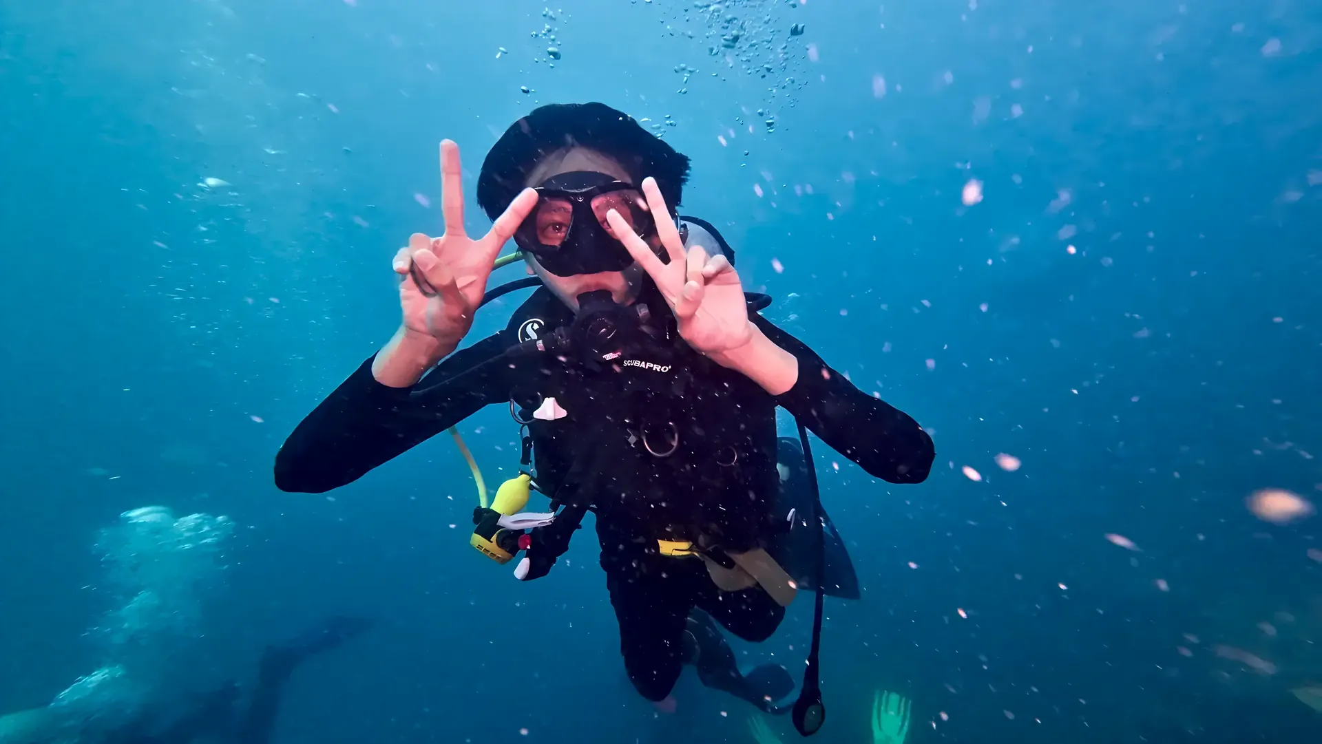 Diver making peace signs in the blue
