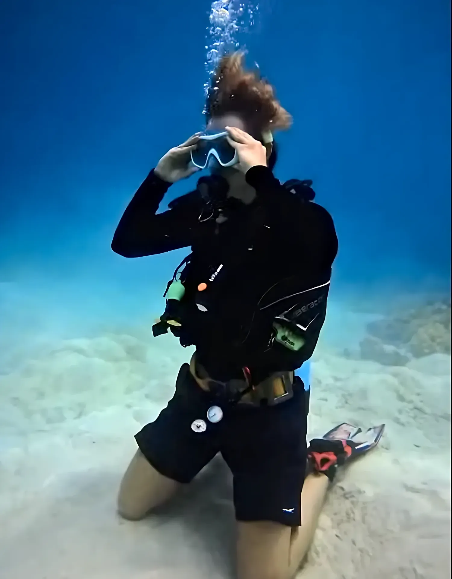First-time diver practicing with a guide on a sandy bottom